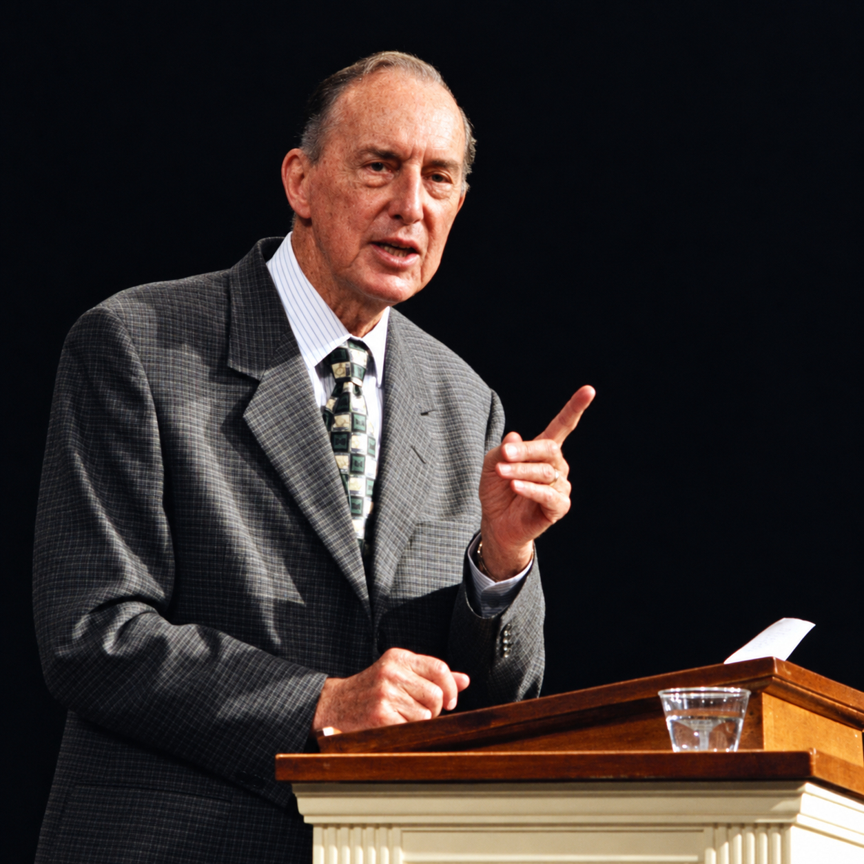 Derek Prince onderwijst achter een katheder